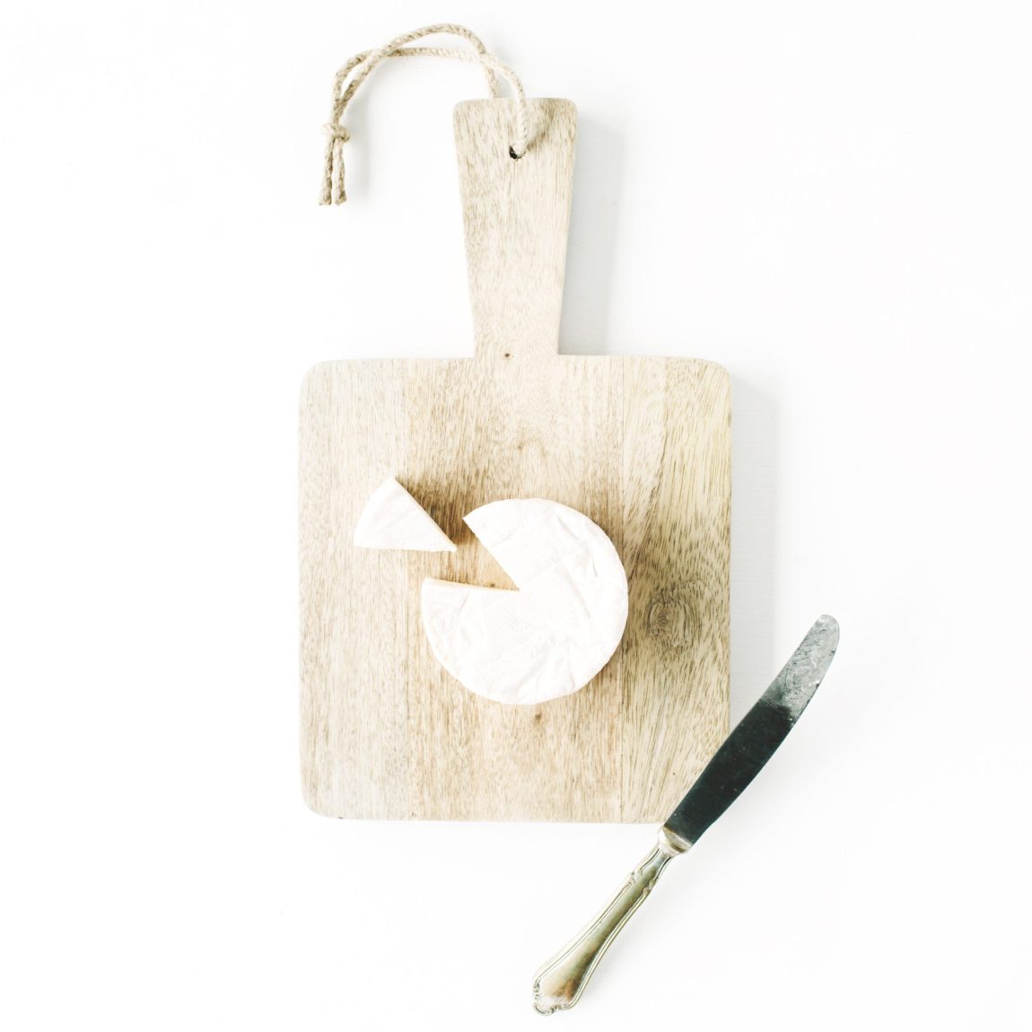 camembert cheese and knife on cutting board. flat lay, top view